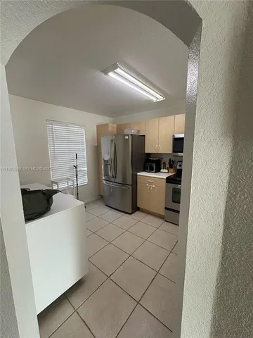 a kitchen with a refrigerator sink and white cabinets
