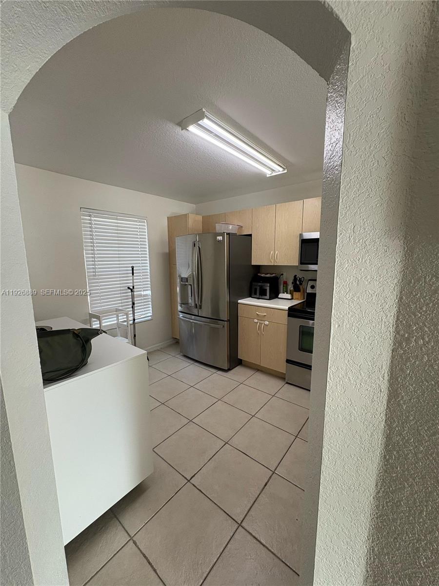 12842 Southwest 31st Street, Unit 134 Miramar, FL 33027 - Photo 6 of 30 a kitchen with a refrigerator sink and white cabinets