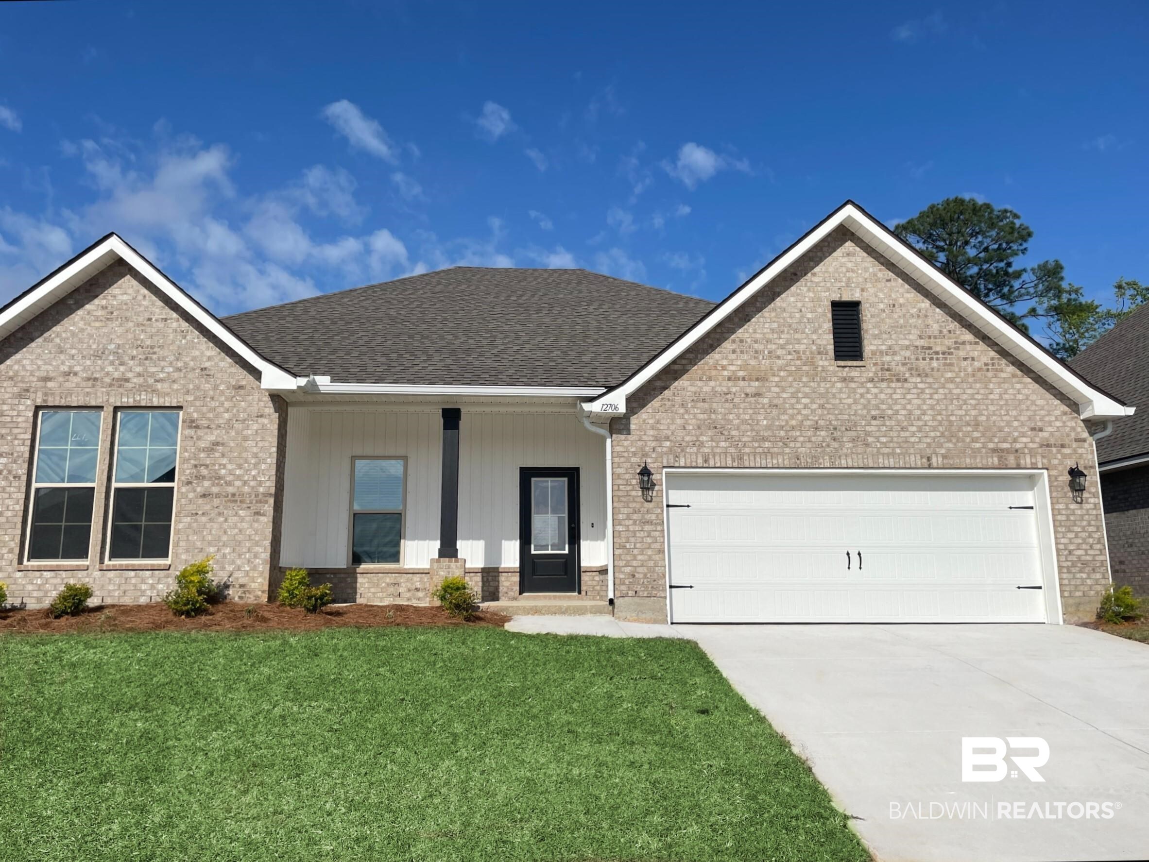 12706 Wagner Avenue Daphne, AL 36527 - Photo 1 of 3 View of front of home featuring an attached garage, brick siding, a front lawn, driveway, and a shingled roof