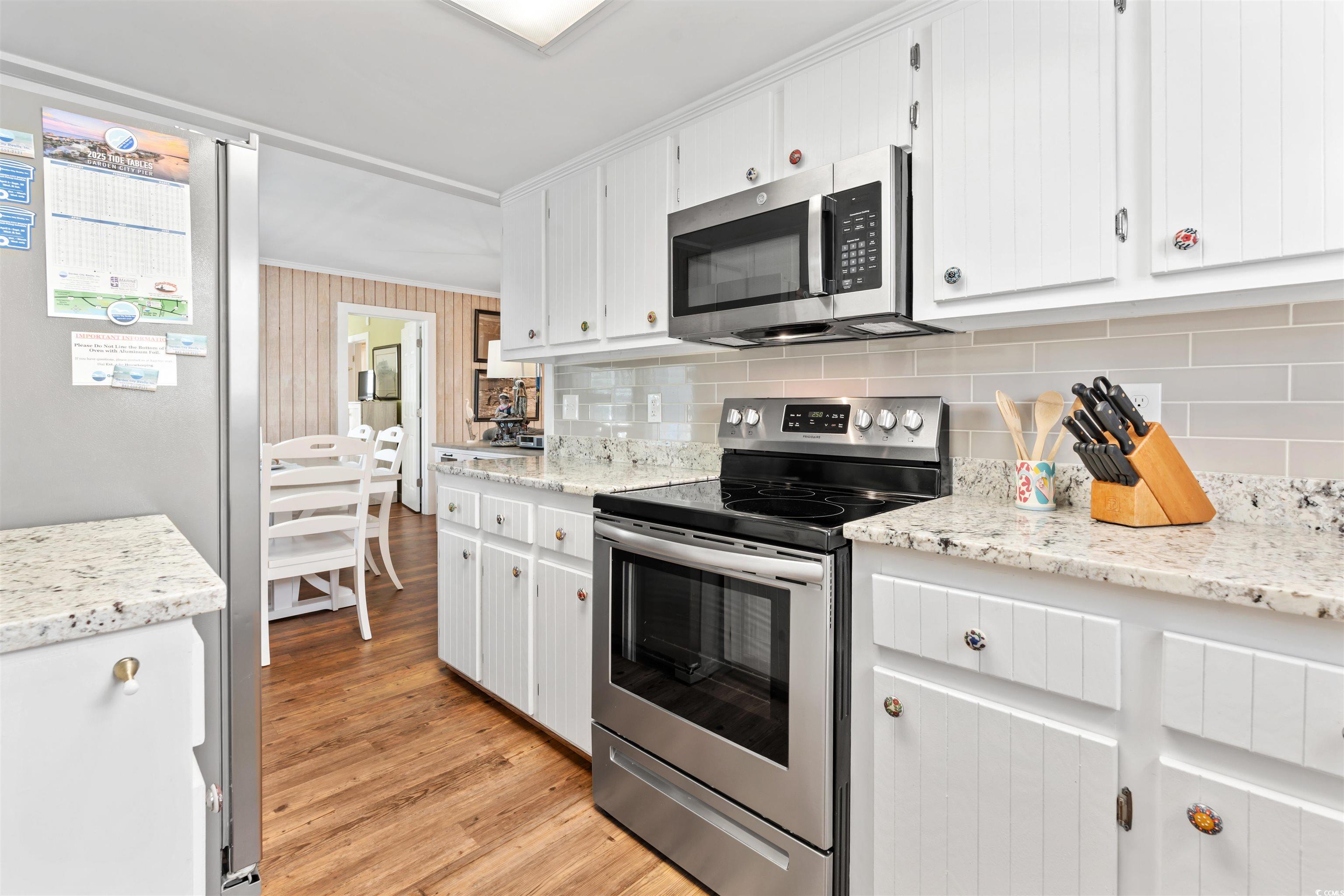 161 Easy Street Murrells Inlet, SC 29576 - Photo 20 of 40 Kitchen with appliances with stainless steel finishes, decorative backsplash, light wood-style flooring, and white cabinets