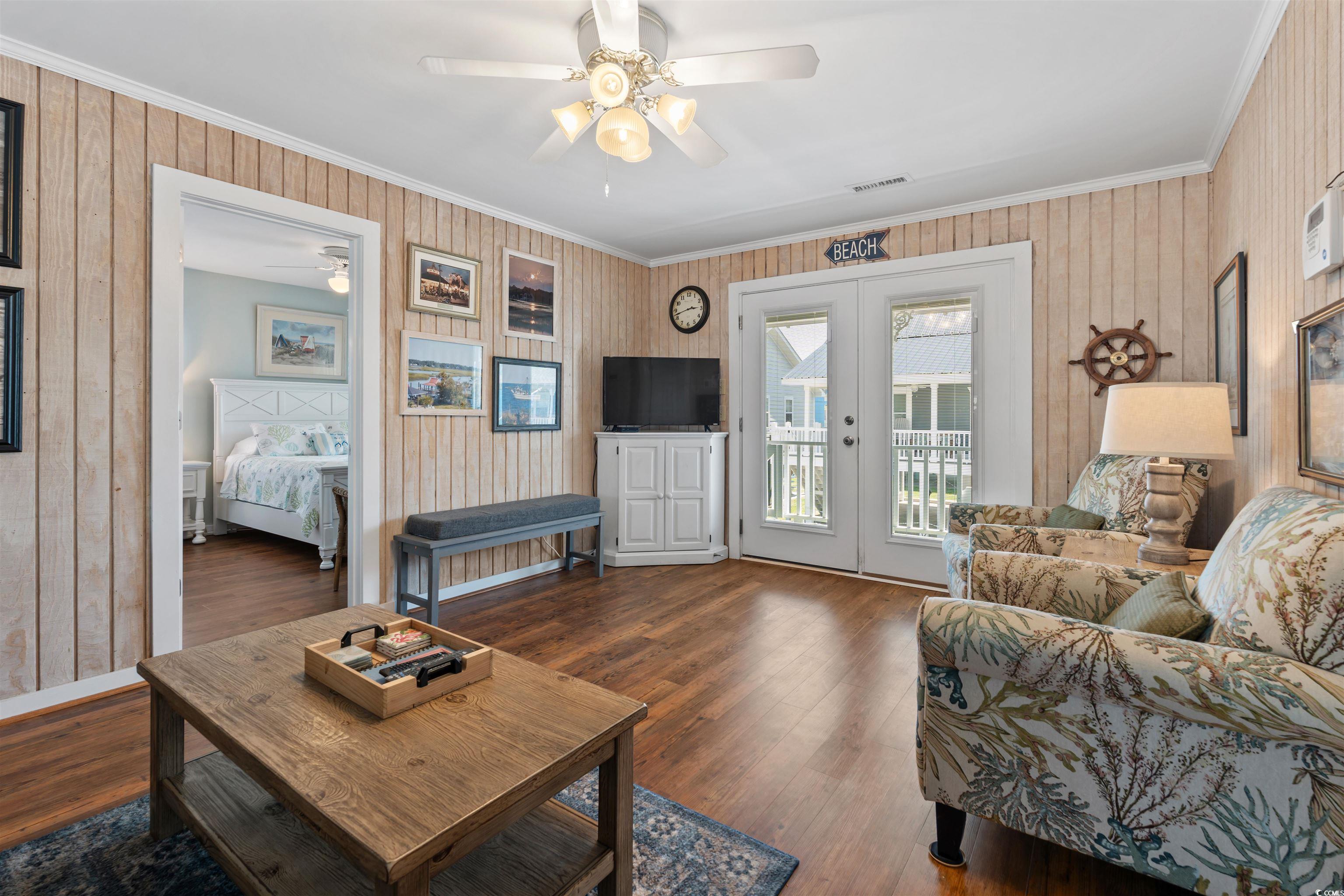161 Easy Street Murrells Inlet, SC 29576 - Photo 5 of 40 Living room with a ceiling fan, ornamental molding, french doors, wood finished floors, and wooden walls