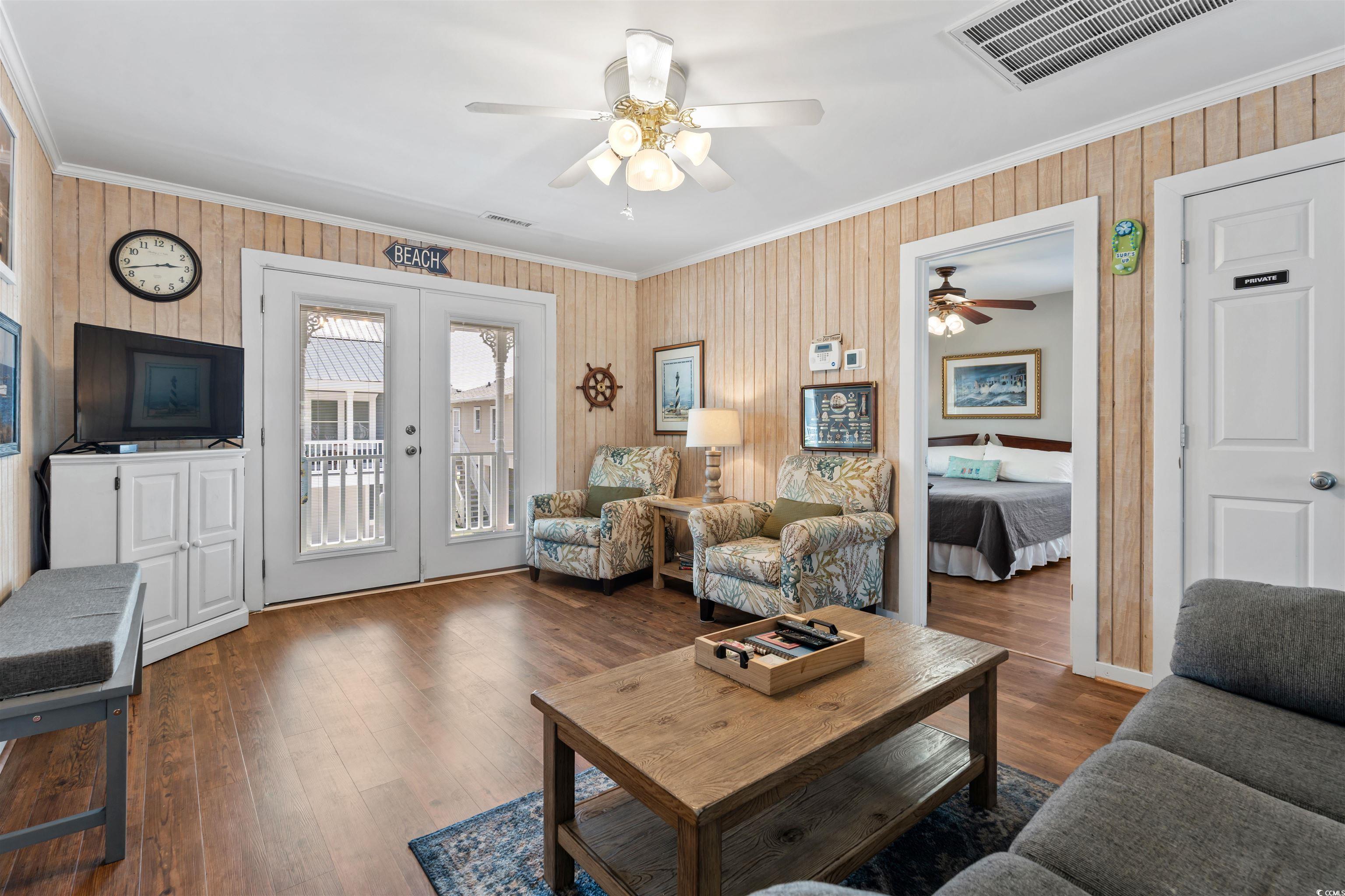 161 Easy Street Murrells Inlet, SC 29576 - Photo 6 of 40 Living area with ornamental molding, french doors, a ceiling fan, wood finished floors, and wood walls