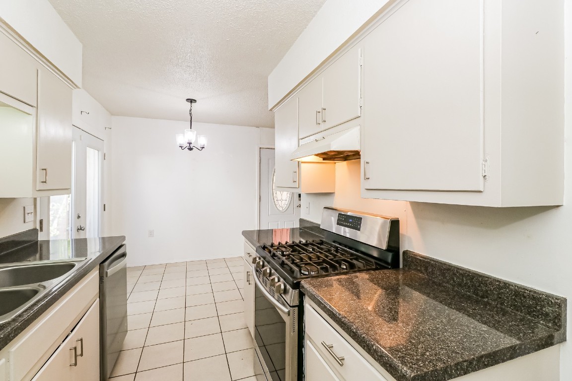 8116 Exmoor Drive, Unit B Austin, TX 78757 - Photo 8 of 15 a kitchen with granite countertop a sink stove and cabinets