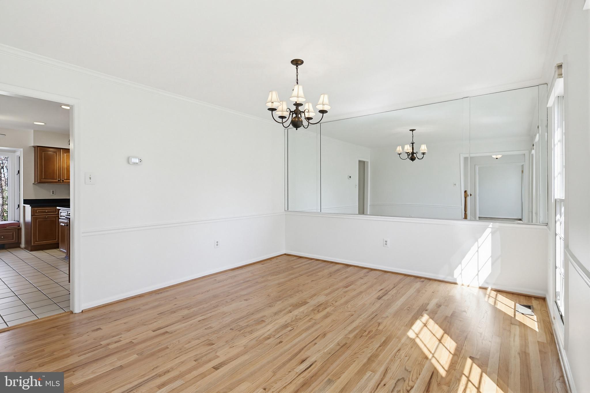 8307 Spring Blossom Court Laurel, MD 20723 - Photo 12 of 69 a view of a room with wooden floor and a chandelier