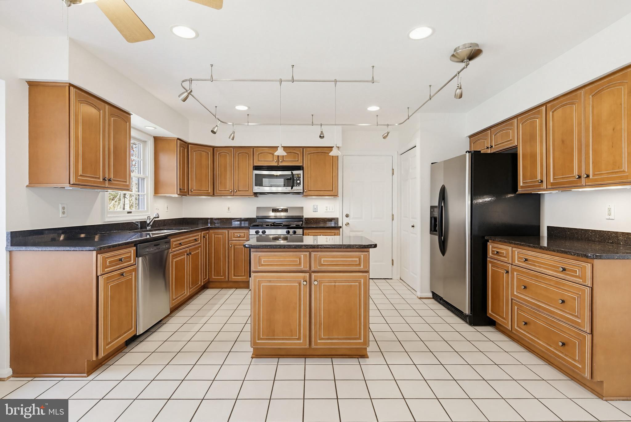 8307 Spring Blossom Court Laurel, MD 20723 - Photo 16 of 69 a kitchen with stainless steel appliances granite countertop a stove top oven a sink dishwasher and a refrigerator with cabinets