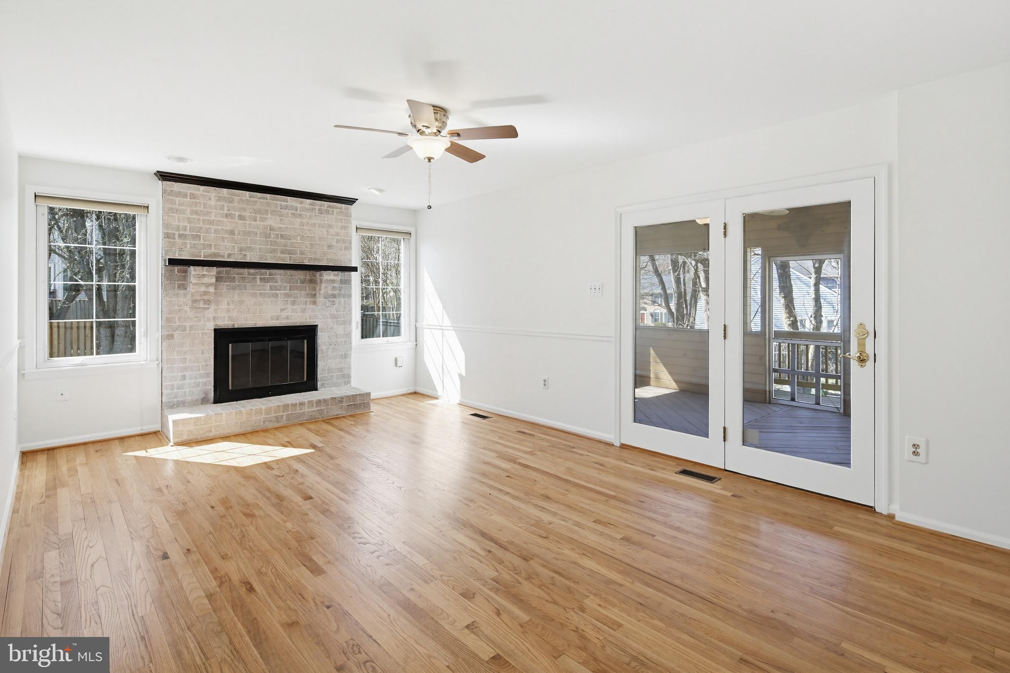 8307 Spring Blossom Court Laurel, MD 20723 - Photo 22 of 69 an empty room with wooden floor fireplace and windows