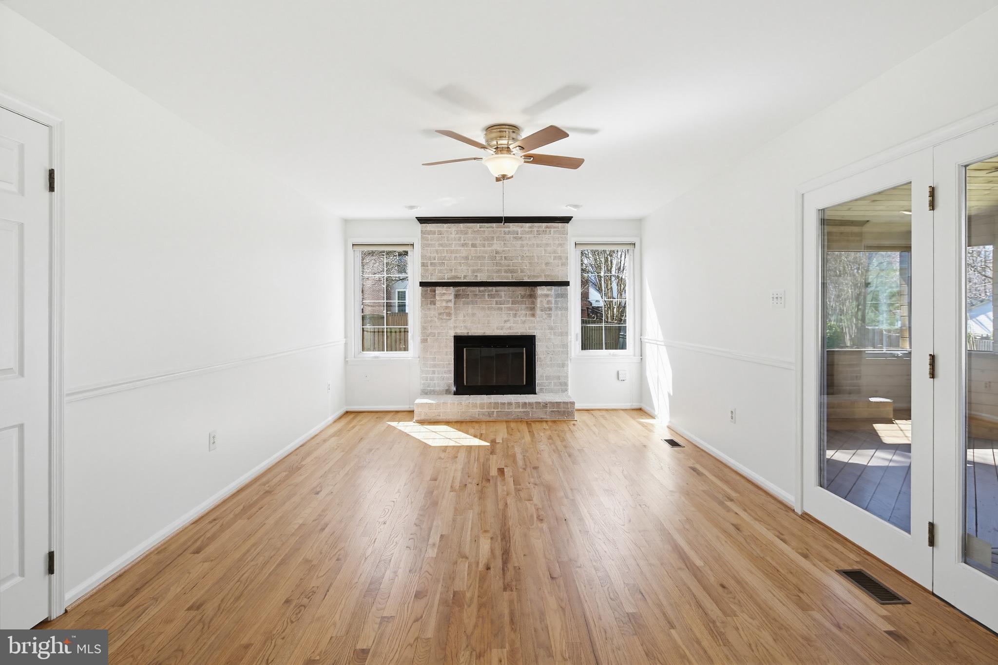 8307 Spring Blossom Court Laurel, MD 20723 - Photo 23 of 69 an empty room with wooden floor fireplace and windows