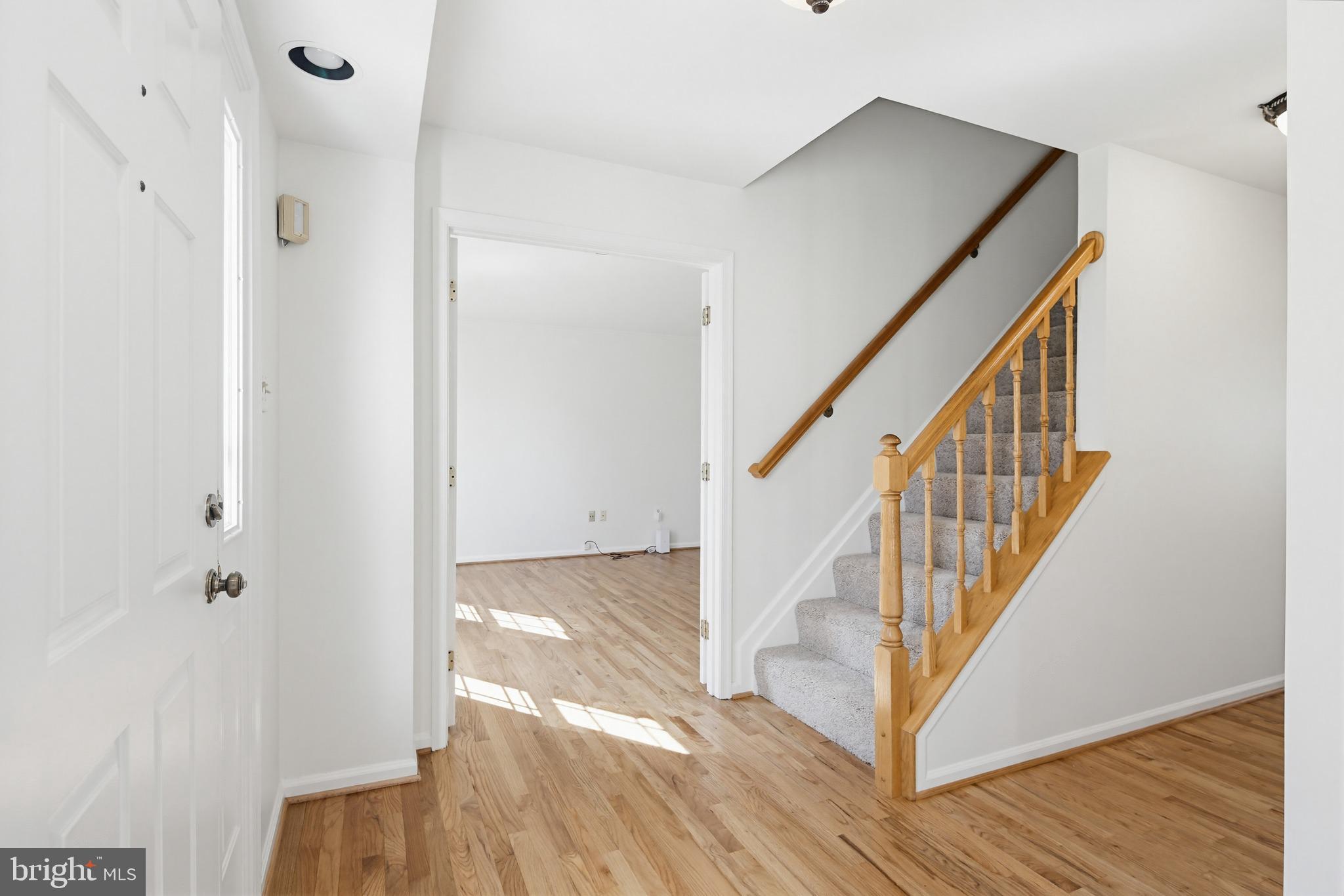 8307 Spring Blossom Court Laurel, MD 20723 - Photo 6 of 69 a view of a hallway with wooden floor and staircase