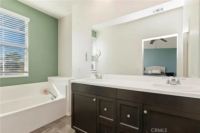 a bathroom with a bathtub double vanity sink and mirror