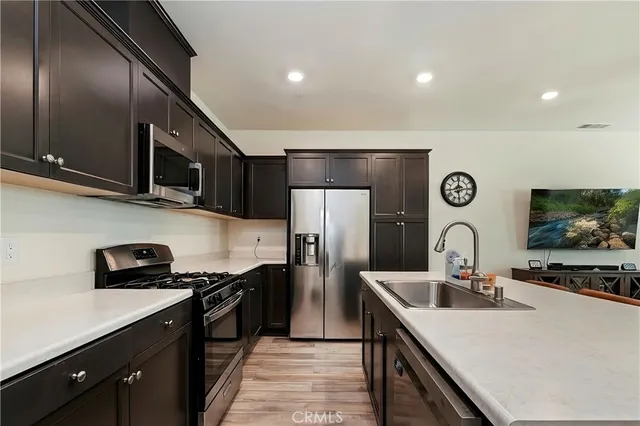 a kitchen with stainless steel appliances a sink a stove and a refrigerator
