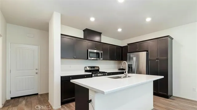 a kitchen with kitchen island stainless steel appliances a sink and refrigerator