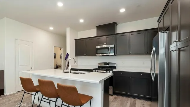 a kitchen with stainless steel appliances a sink cabinets and wooden floor