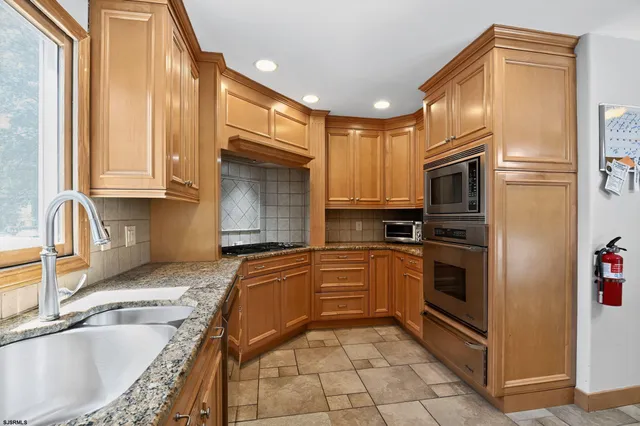 a kitchen with granite countertop sink window and cabinets