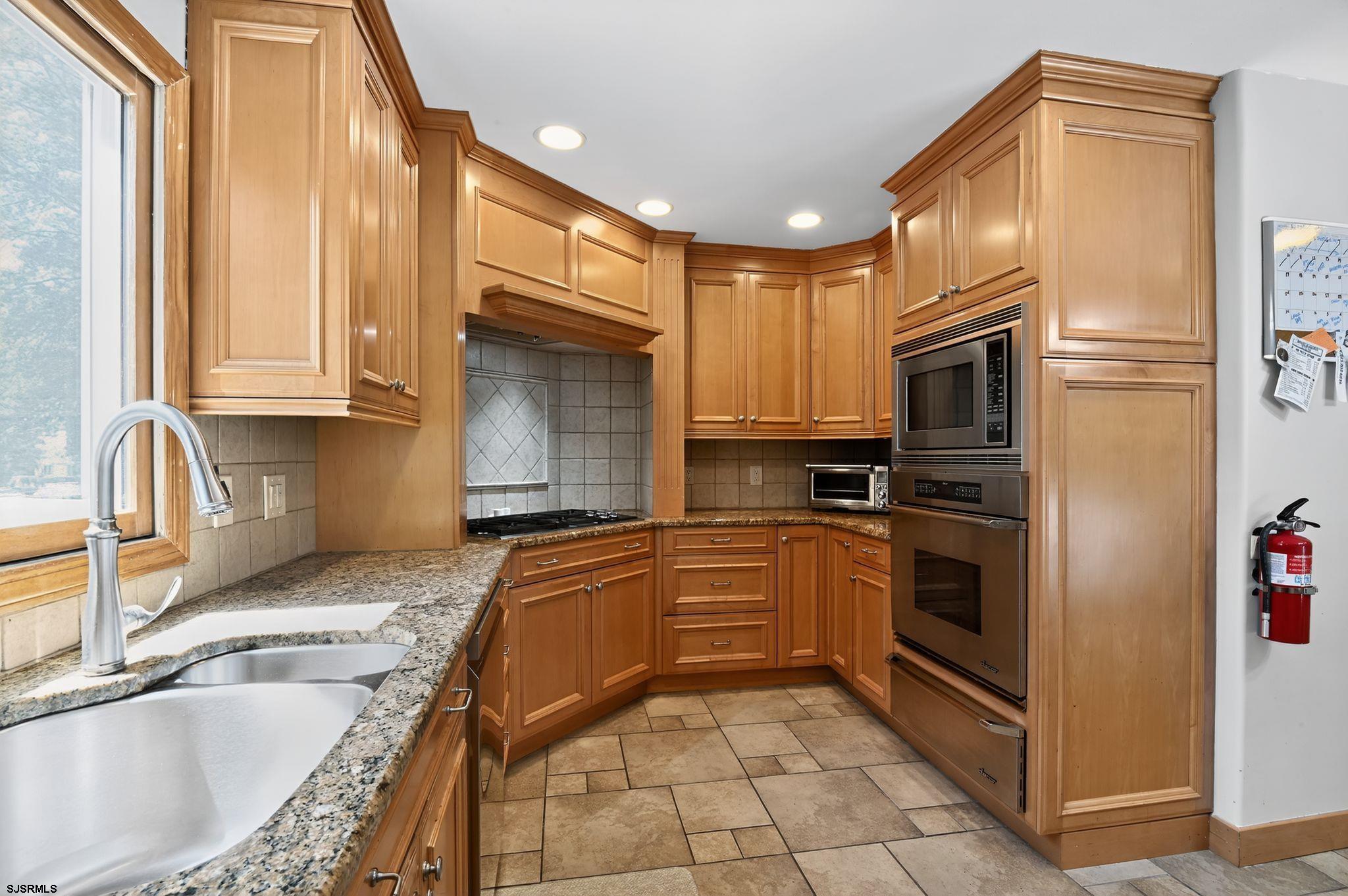 404 Cedarbrook Lane Linwood, NJ 08221 - Photo 14 of 33 a kitchen with stainless steel appliances granite countertop a sink stove and refrigerator