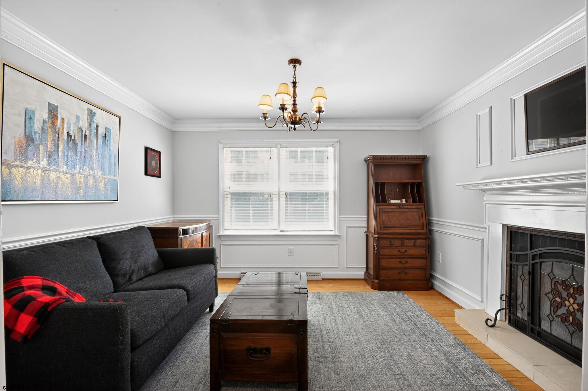 404 Cedarbrook Lane Linwood, NJ 08221 - Photo 19 of 33 a living room with furniture a flat screen tv and a fireplace