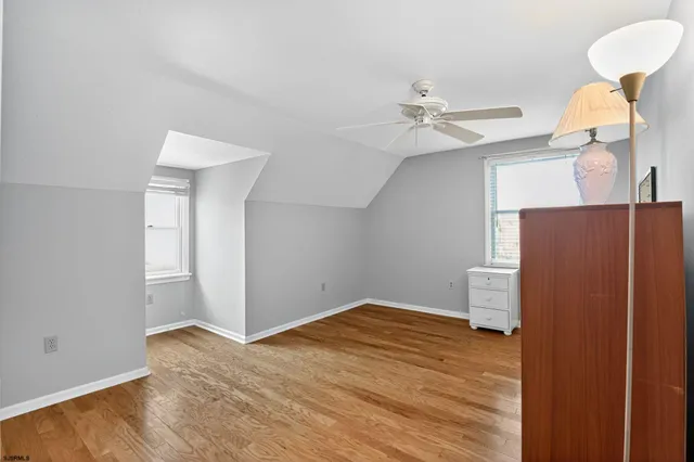 a living room with furniture a flat screen tv and a refrigerator