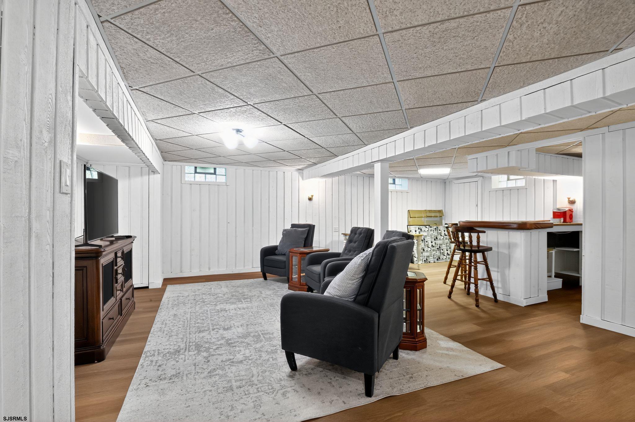 404 Cedarbrook Lane Linwood, NJ 08221 - Photo 28 of 33 a living room with furniture a flat screen tv and a refrigerator