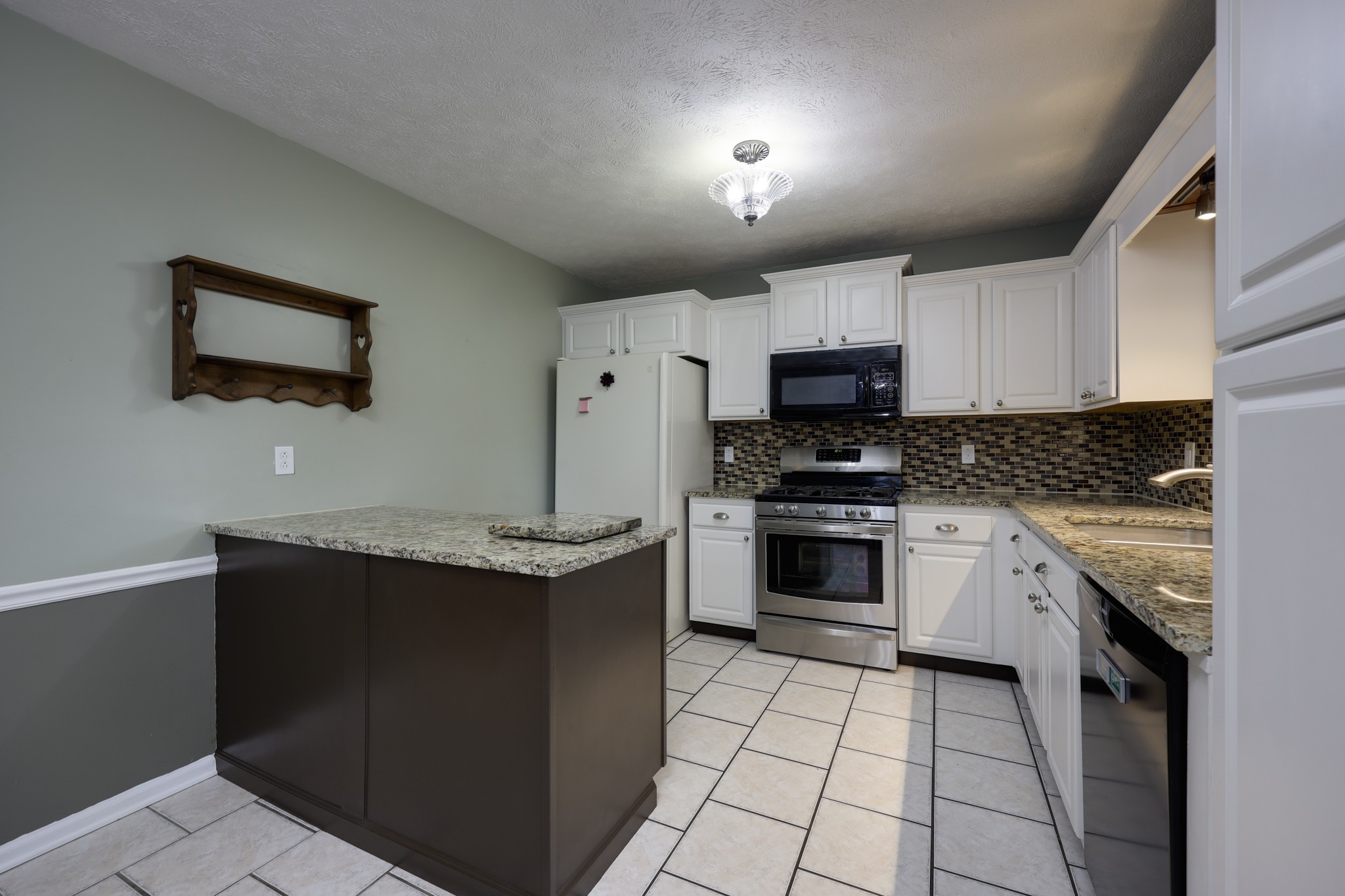 5113 Baker Road Murfreesboro, TN 37129 - Photo 4 of 17 a kitchen with granite countertop a stove top oven and cabinets