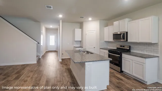 a kitchen with stainless steel appliances granite countertop a sink stove and refrigerator