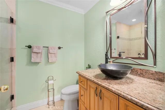 a bathroom with a granite countertop toilet a sink and a mirror