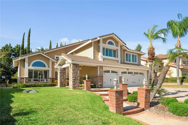 a front view of a house with a yard and potted plants
