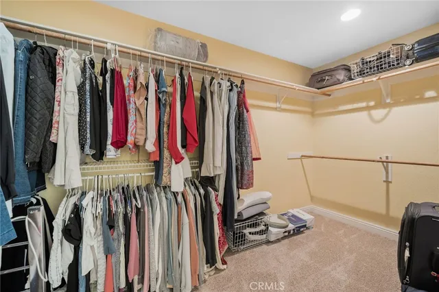 a view of walk in closet with clothes