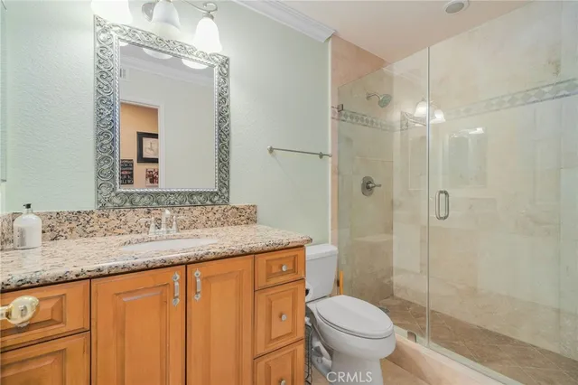 a bathroom with a granite countertop sink toilet and shower