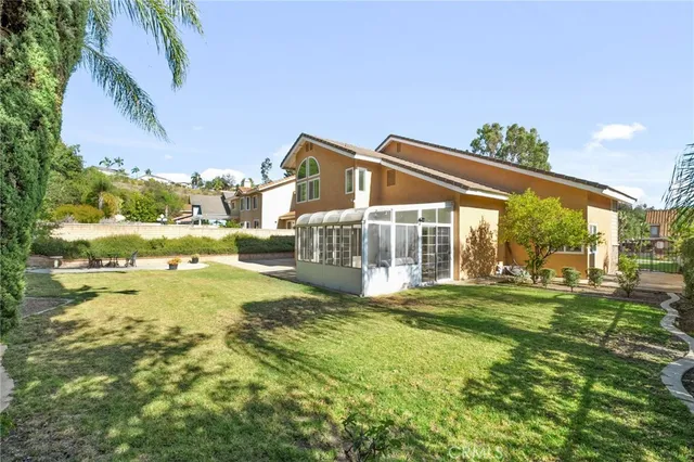 a view of a big house with a big yard and large trees