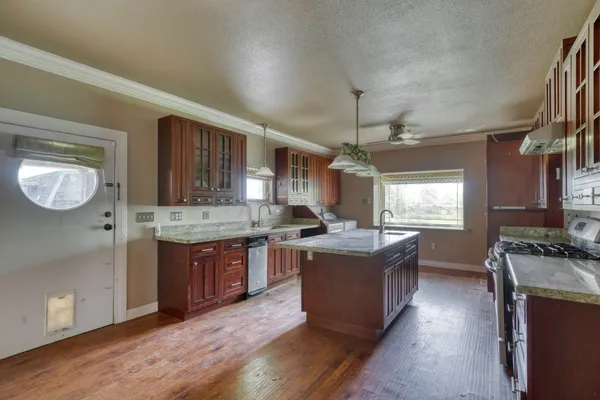 a kitchen with granite countertop a stove and cabinets