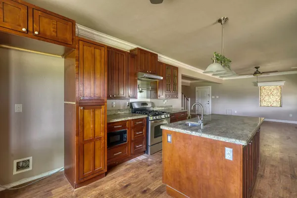 a kitchen with stainless steel appliances granite countertop a sink a stove and a refrigerator