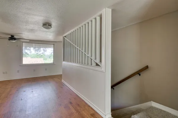 a view of an empty room with a window and a ceiling fan