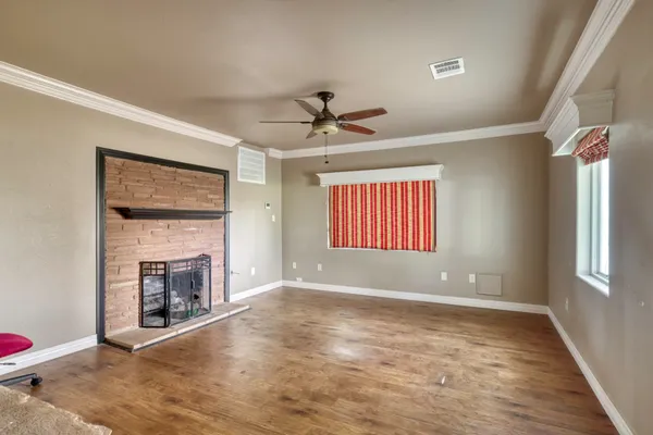 an empty room with windows and fireplace