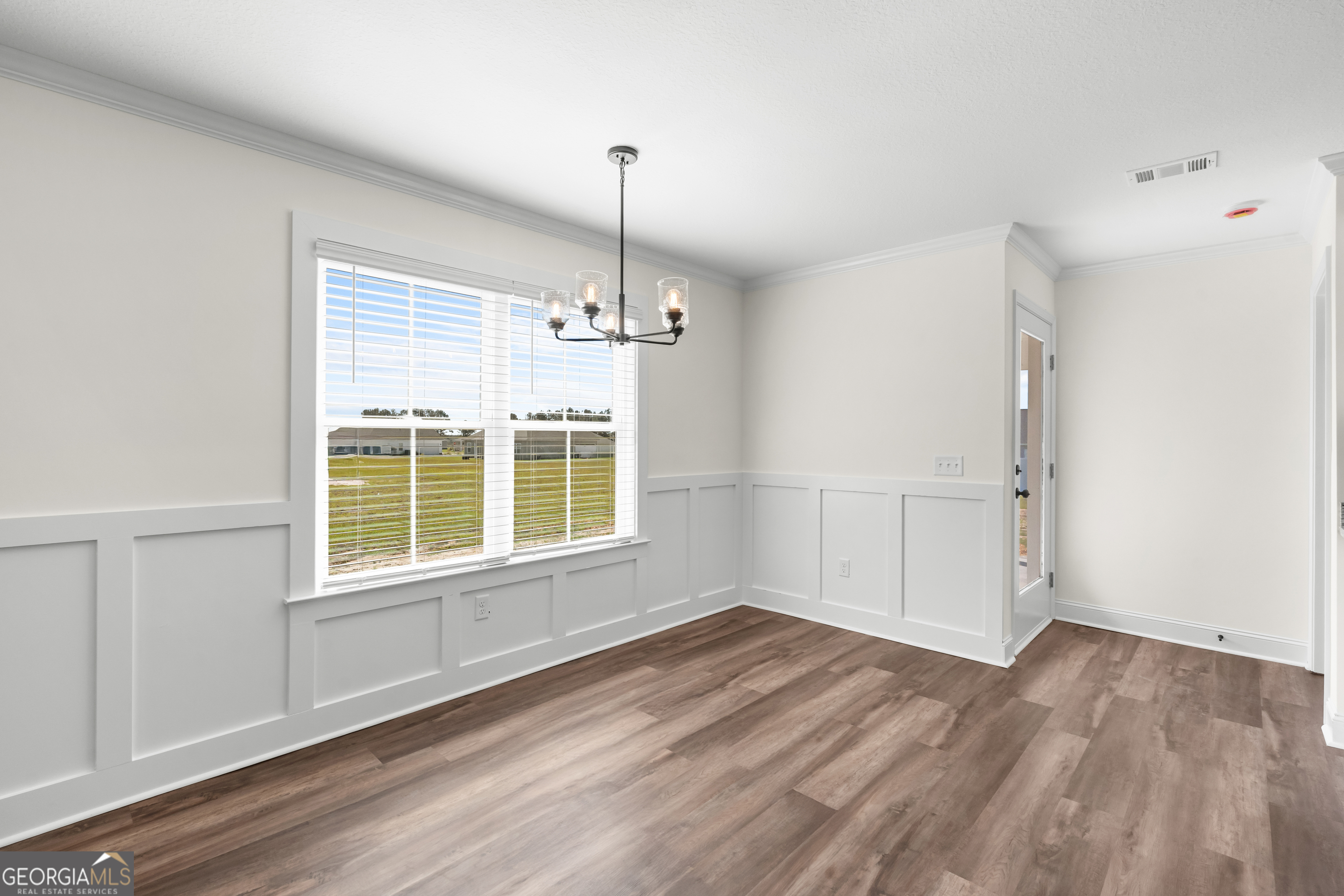 919 Ryegrass Road Statesboro, GA 30458 - Photo 7 of 20 an empty room with wooden floor cabinet and windows