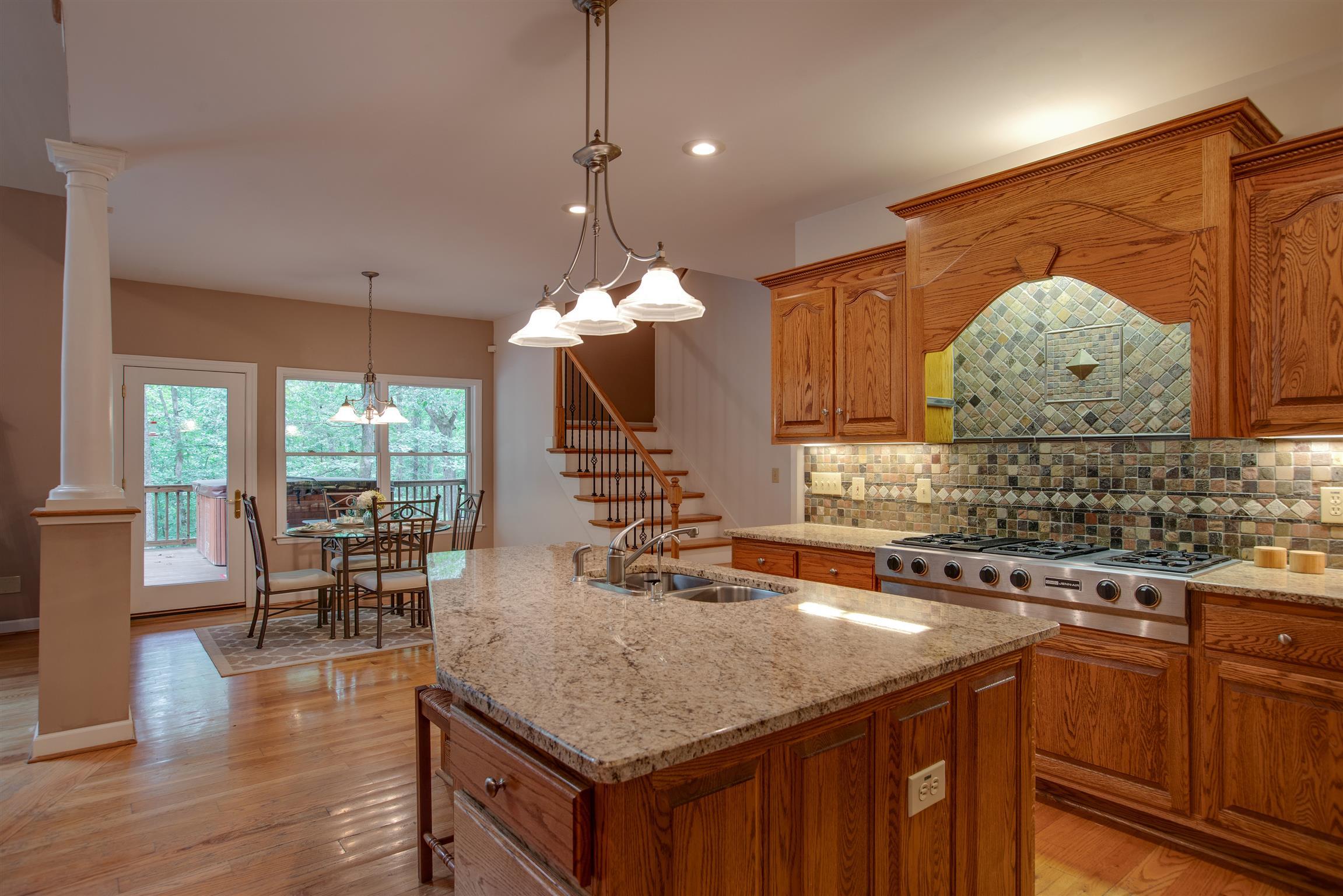 5745 Pinewood Road Franklin, TN 37064 - Photo 7 of 27 a kitchen with stainless steel appliances granite countertop a sink a stove and a wooden floors