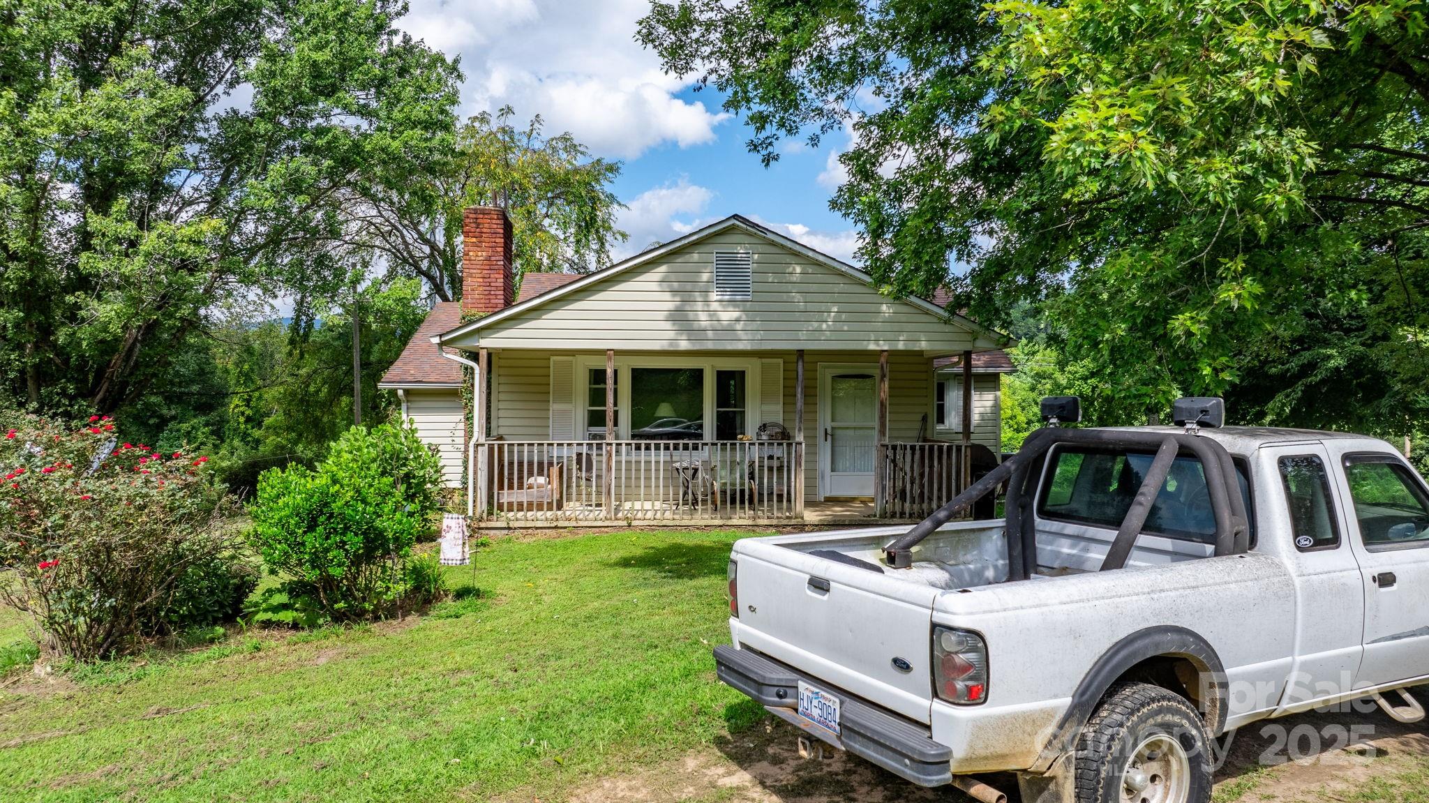 1147 Old Linville Road Marion, NC 28752 - Photo 3 of 27 a white house covered with tall trees