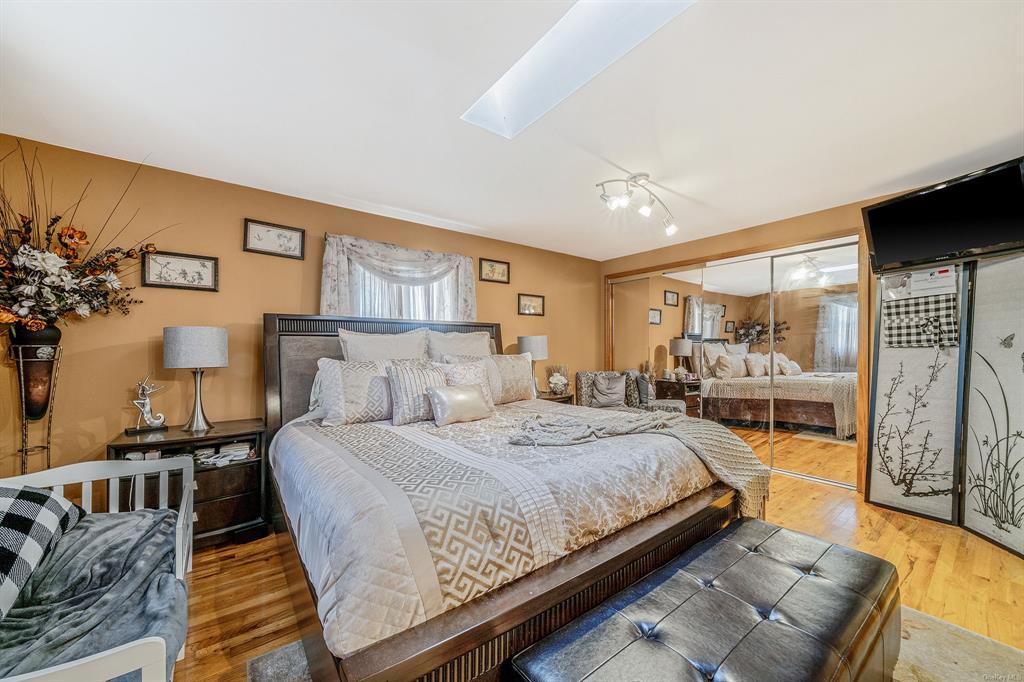 8 Brenner Road Coram, NY 11727 - Photo 18 of 43 a bedroom with a large bed couch and a window