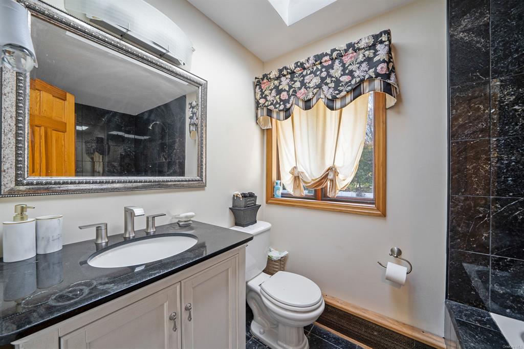 8 Brenner Road Coram, NY 11727 - Photo 23 of 43 a bathroom with a granite countertop sink and a mirror