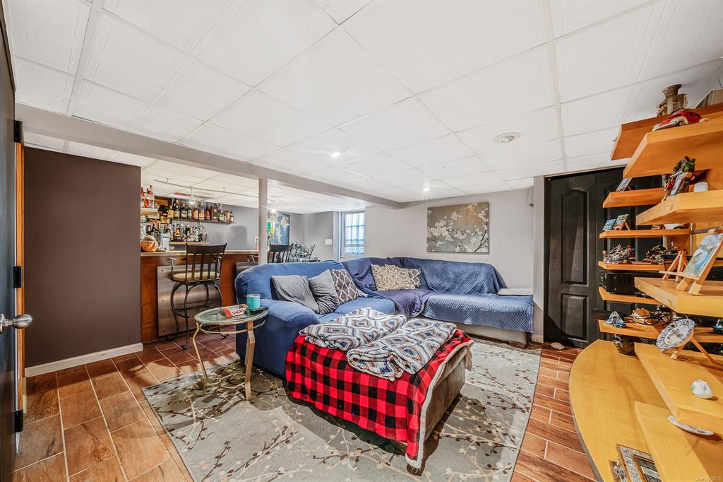 8 Brenner Road Coram, NY 11727 - Photo 26 of 43 a living room with furniture a flat screen tv and a rug