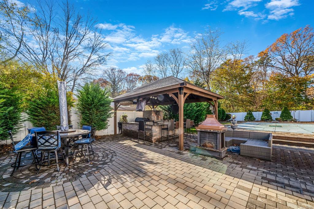 8 Brenner Road Coram, NY 11727 - Photo 30 of 43 a view of a patio with a table and chairs under an umbrella
