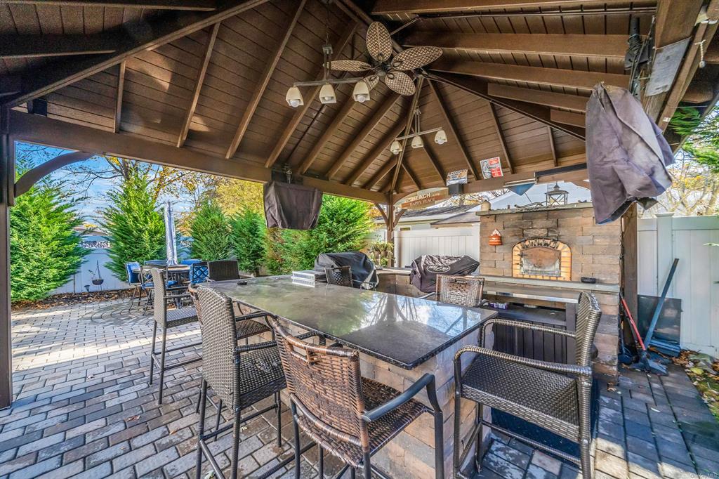 8 Brenner Road Coram, NY 11727 - Photo 31 of 43 a view of a backyard with table and chairs under an umbrella with a small yard