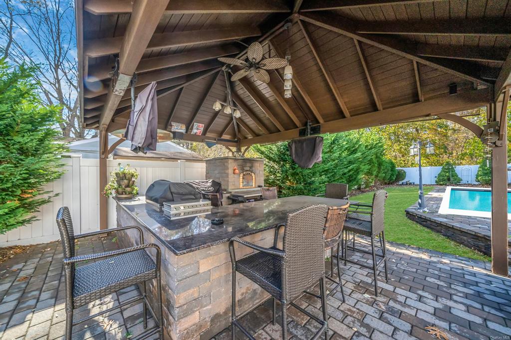 8 Brenner Road Coram, NY 11727 - Photo 32 of 43 a view of a patio with table and chairs under an umbrella
