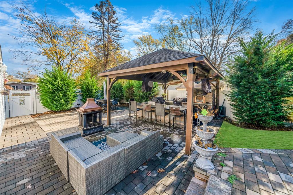 8 Brenner Road Coram, NY 11727 - Photo 34 of 43 a view of a patio with table and chairs potted plants and large tree