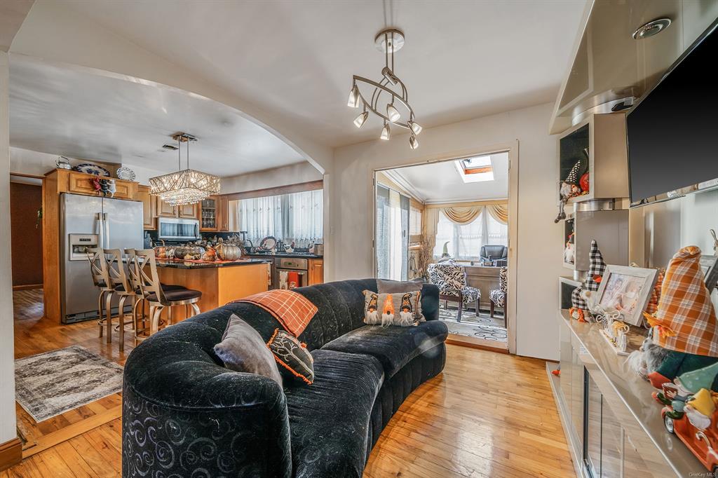 8 Brenner Road Coram, NY 11727 - Photo 9 of 43 a living room with furniture kitchen view and a chandelier