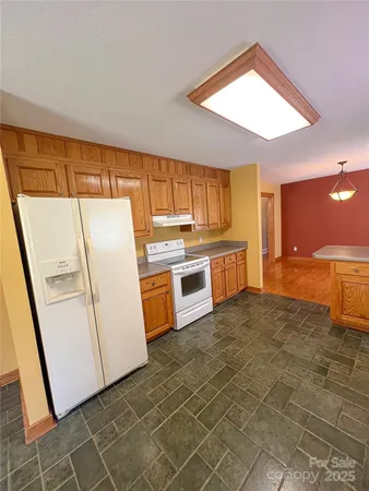 a kitchen with granite countertop a refrigerator a sink a stove a washer and dryer