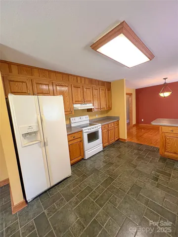 a kitchen with granite countertop a refrigerator a sink a stove a washer and dryer