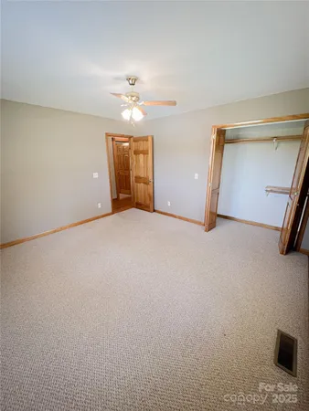 an empty room with a ceiling fan and window