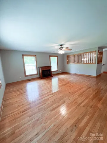 a view of a livingroom with wooden floor and a kitchen space