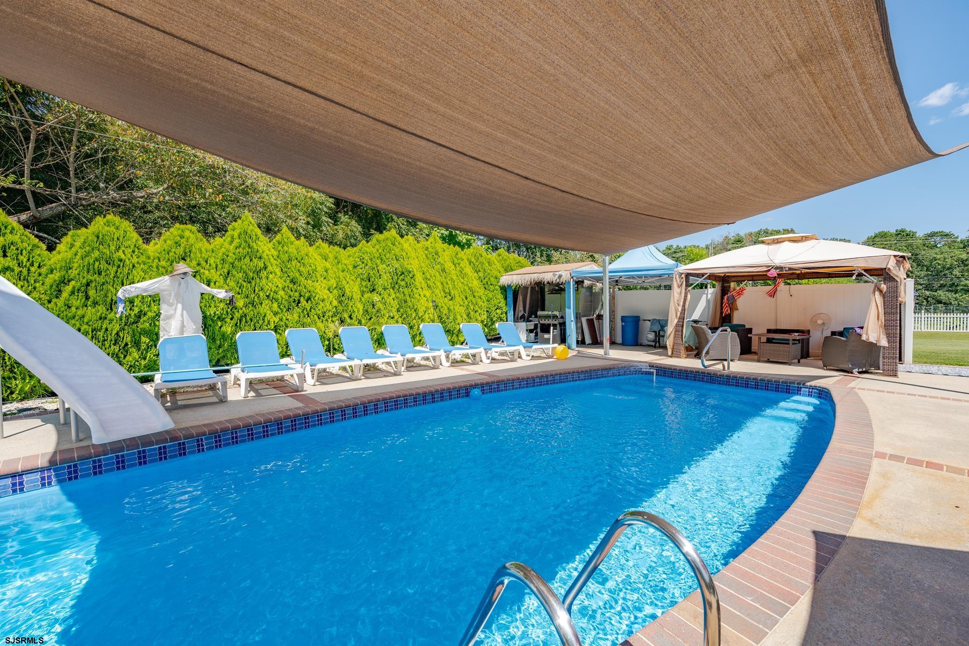 6529 Delilah Road Egg Harbor Township, NJ 08234 - Photo 53 of 70 a view of a swimming pool with lawn chairs and couches