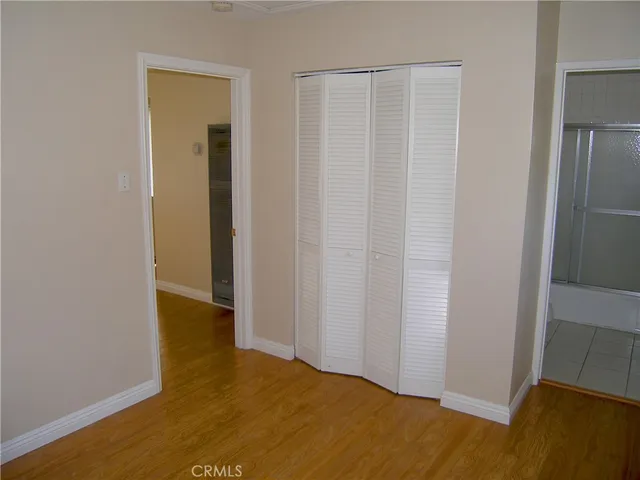 an empty room with wooden floor and closet