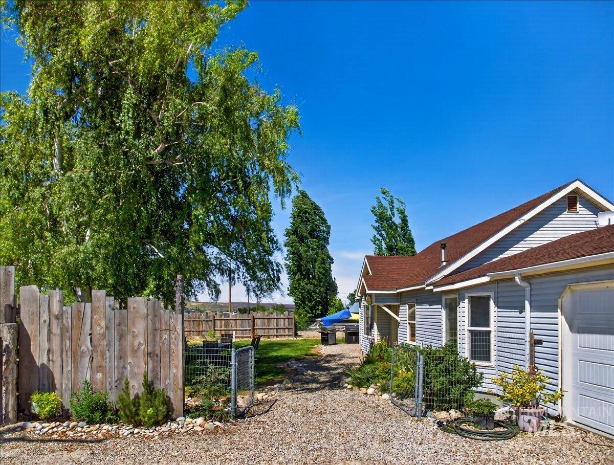 2588 West Sales Yard Road Emmett, ID 83617 - Photo 11 of 49 Gravel driveway accessing a light-colored siding residence with a brown shingle roof